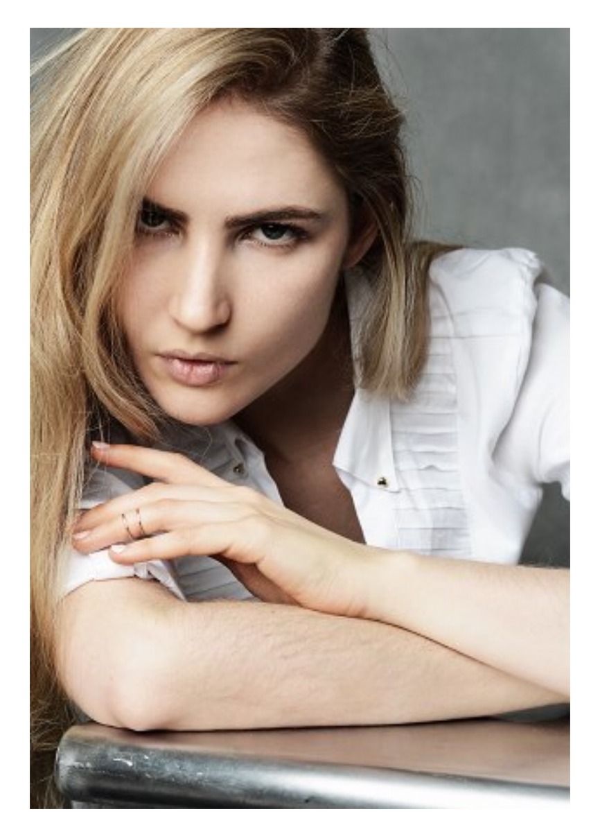 Ali Kirsch leaning forward in a white-shirt editorial portrait