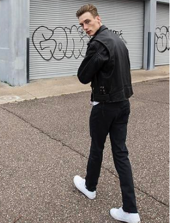 Austen turning toward the camera in a black leather jacket