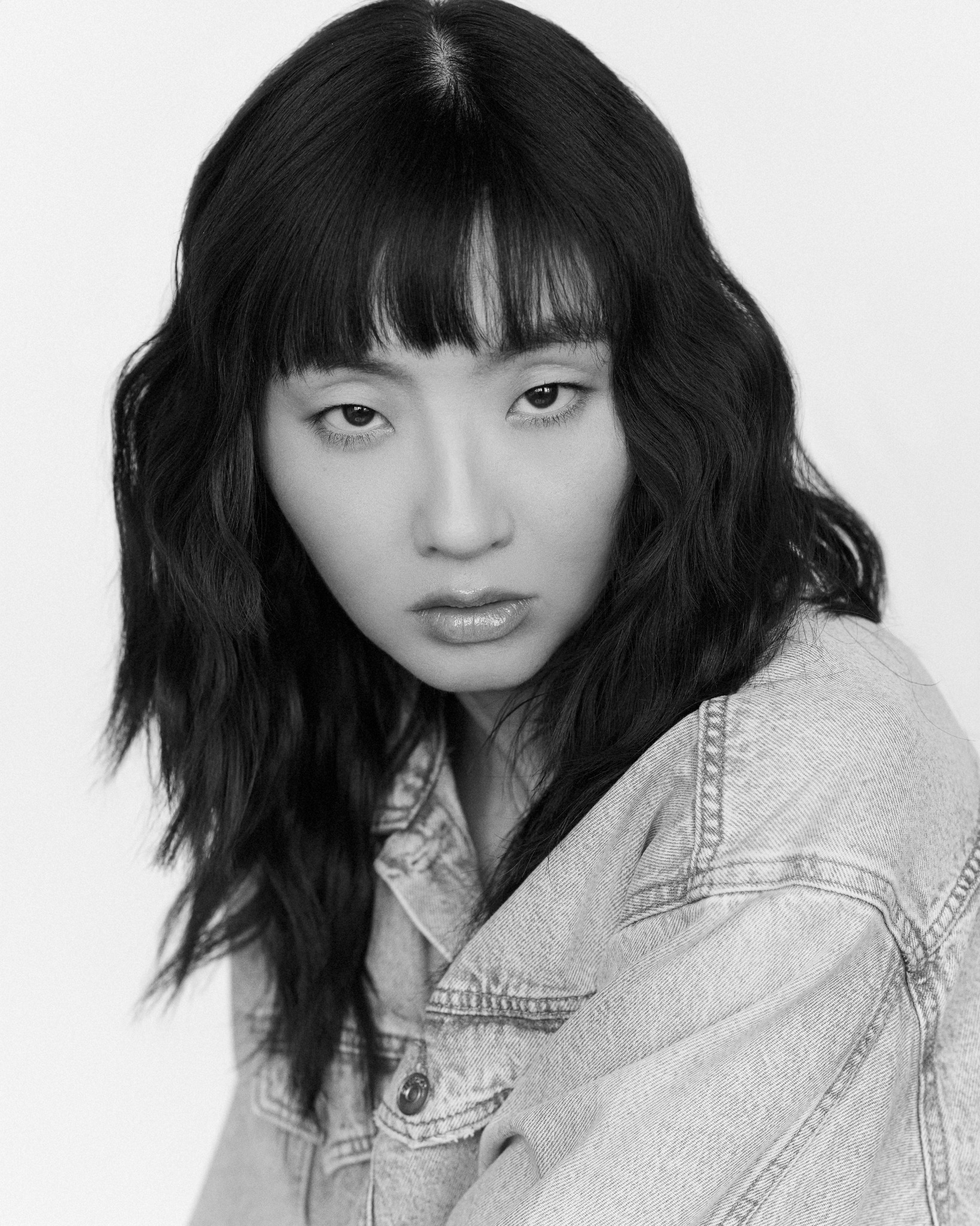 Tian in a black-and-white close portrait wearing denim